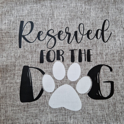 A light grey cushion cover with 'Reserved for the Dog' text and a paw in Australia made by Rieko's World.
