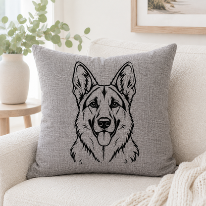 A square gray throw pillow with a black line art illustration of a German Shepherd dog, resting on a cream-colored sofa in a bright, modern living room setting.