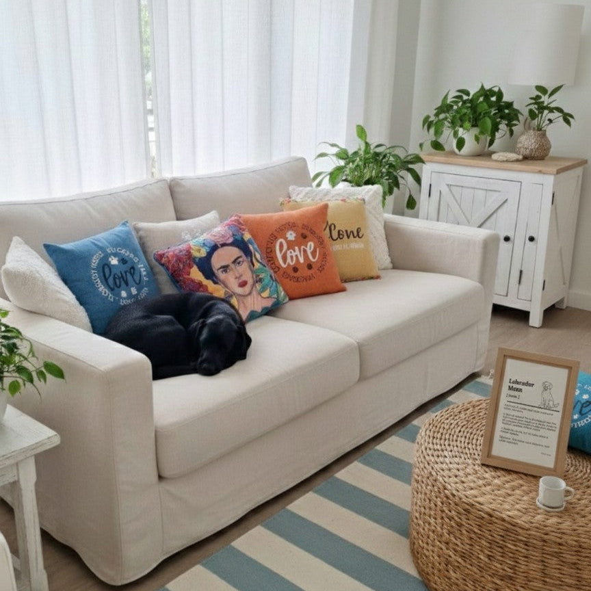 Living room with a beige sofa, colorful pillows, and a striped rug.