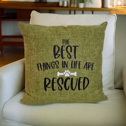 A close up of a green cushion cover with text the best things in life are rescued on beige sofa in Australia by Rieko's World.