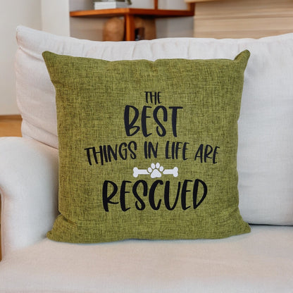 A green cushion cover with the text 'THE BEST THINGS IN LIFE ARE RESCUED' printed on it, placed on a white sofa cushion - Dog gift, Australia by Rieko's World