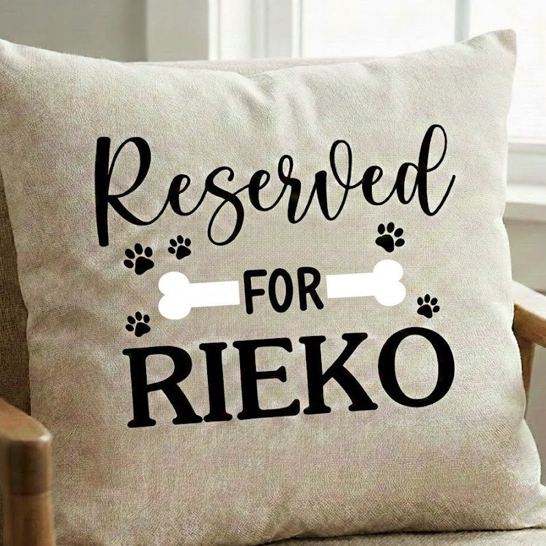 Beige pillow with 'Reserved for Rieko' text on a chair.