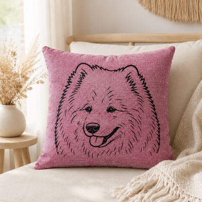 A square pink throw pillow with a black line-art illustration of a fluffy dog face, styled on a cream sofa with a beige throw blanket and dried flowers in a vase.