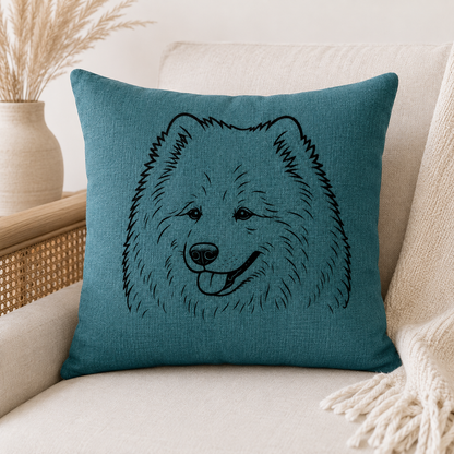 A square teal throw pillow with a black line art illustration of a fluffy dog face, resting on a beige sofa next to a cream throw blanket and a vase with dried grass.