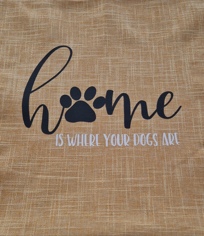 A close up of a yellow cushion cover with the text 'Home is Where Your Dogs Are' and a paw print design - Dog gift, Australia by Rieko's World